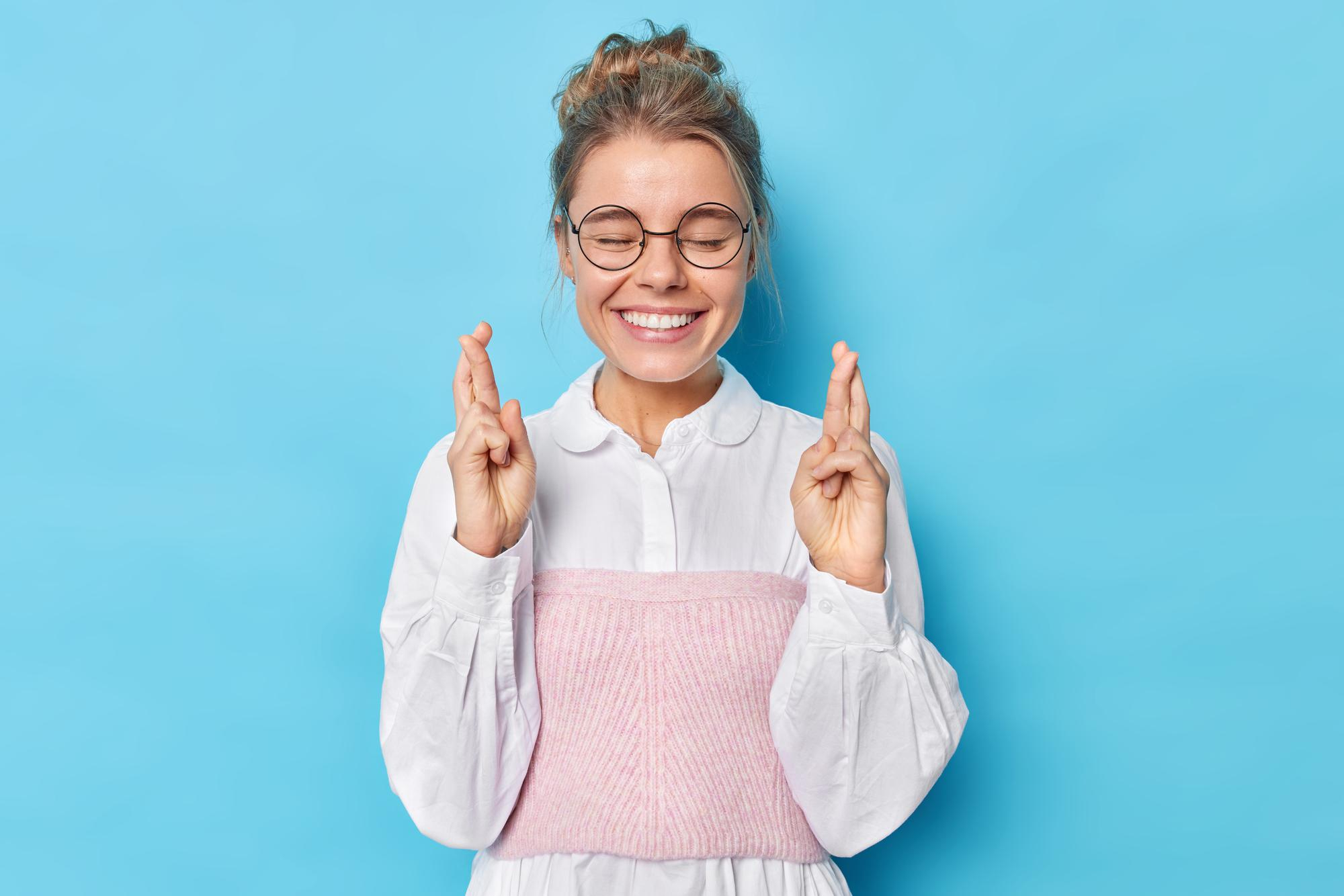 Excited girl with fingers crossed