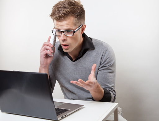 A Man at His Computer Talking Angrily on the Phone
