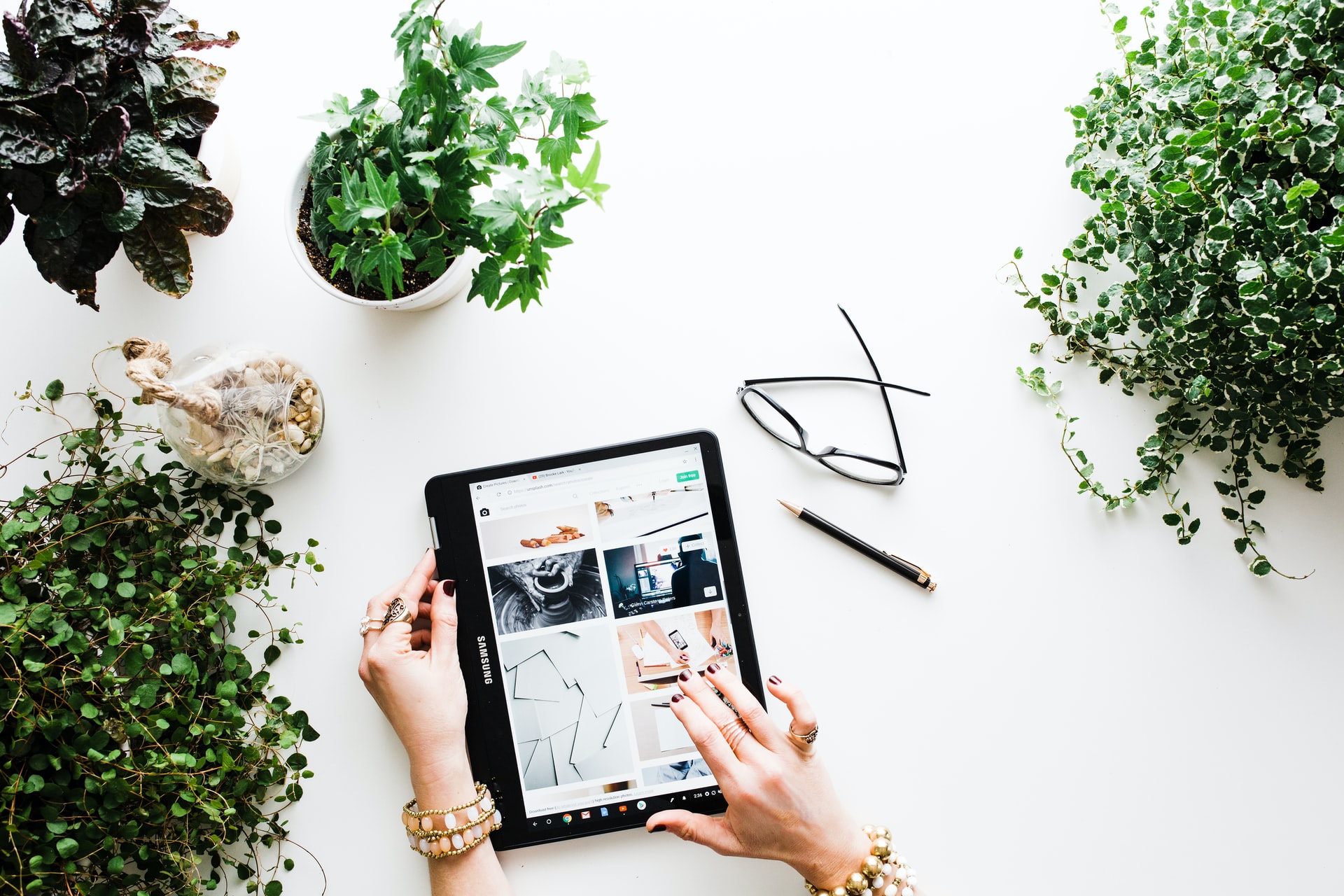 A tablet surrounded with green plants