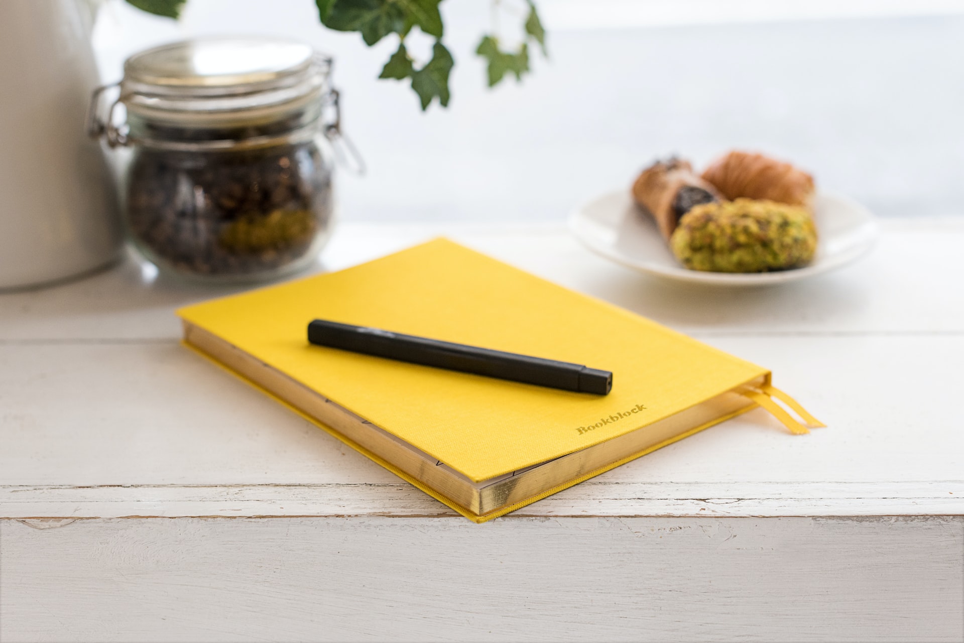 Yellow notebook with a black pen on top
