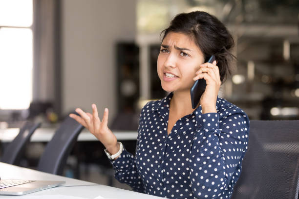 A frustrated and confused woman talking on the phone