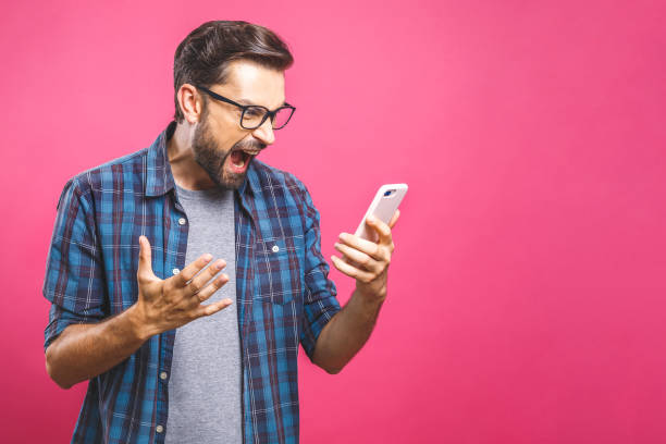 A man look at his smartphone in disbelief and anger