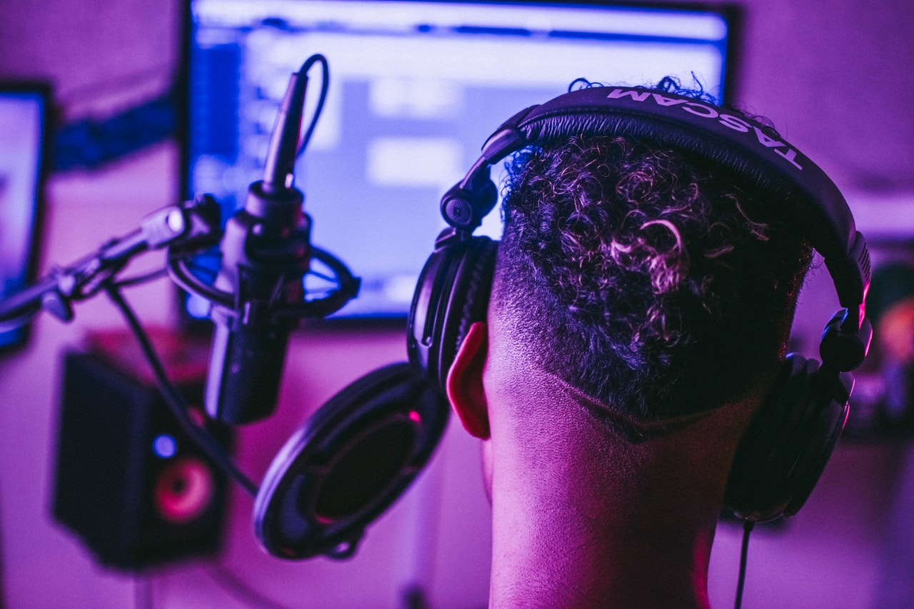 Man wearing a headset in front of a microphone