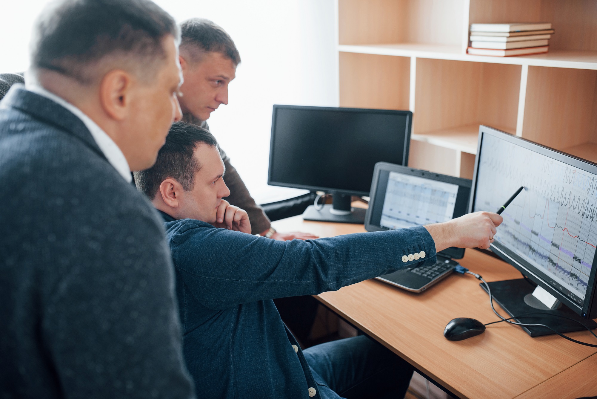 Group of men discussing the analytics on a screen