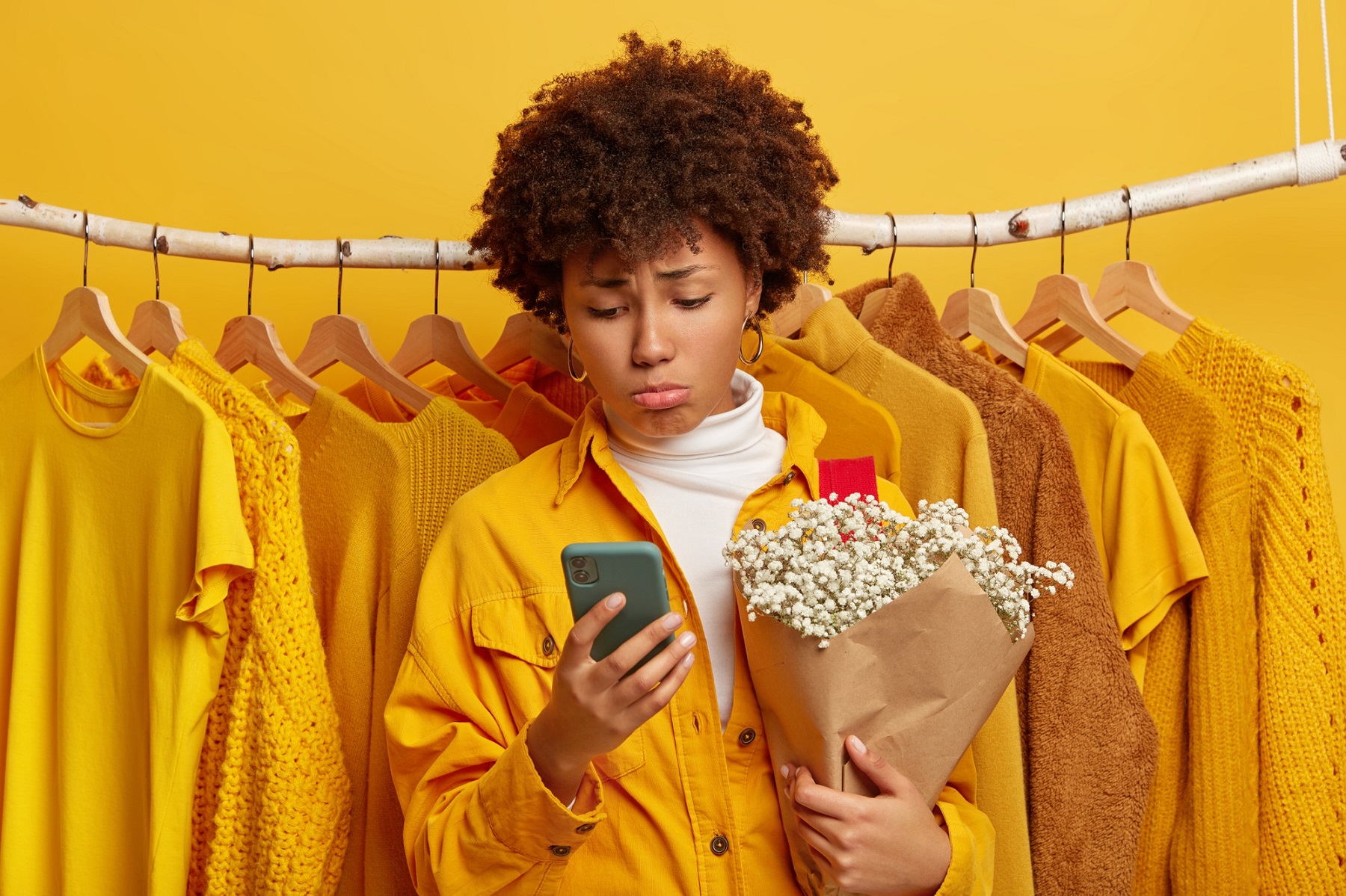 An unhappy customer with a sad face holding a smartphone