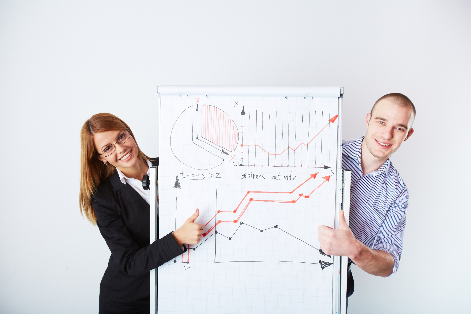 A man and a woman holding a paper with graphs and a chart on it