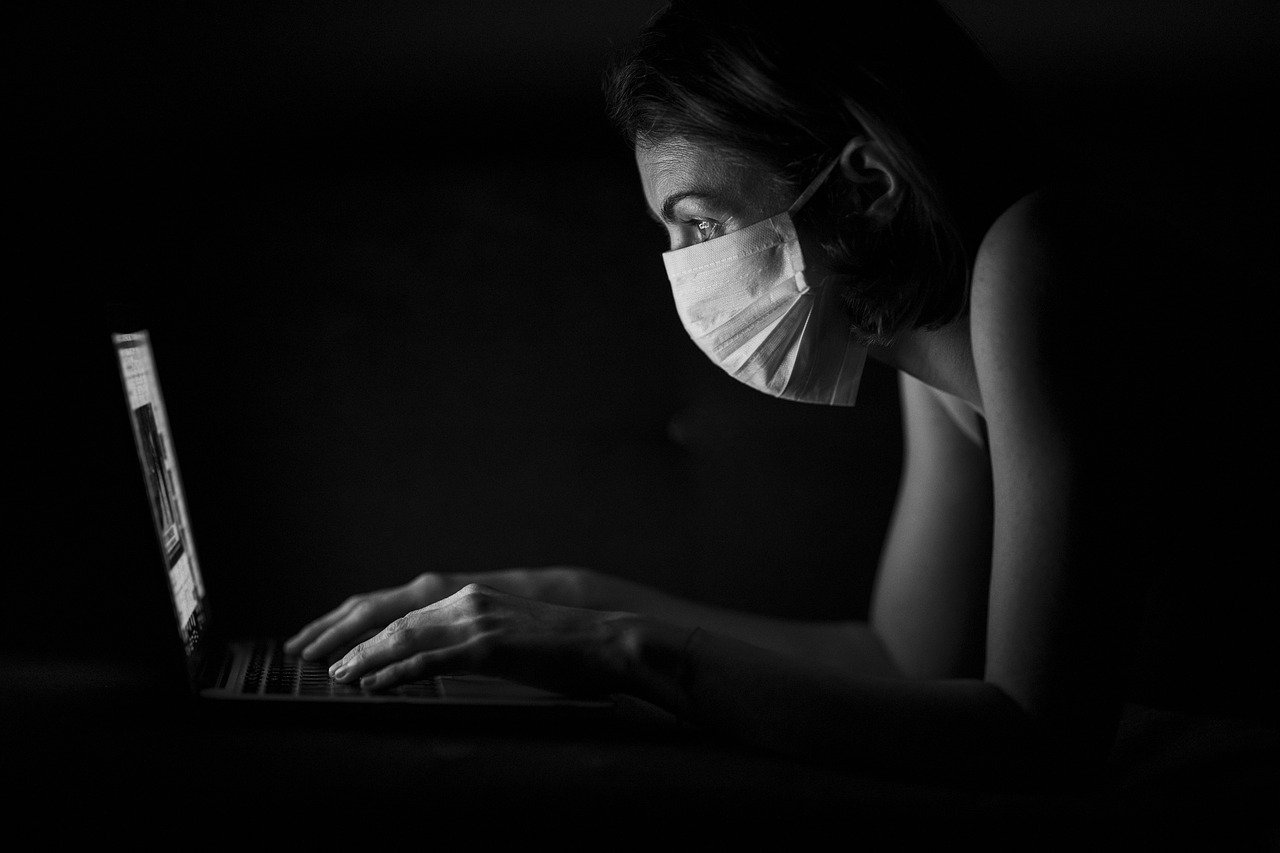 Woman Shopping Online While Wearing a Mask during the Coronavirus Pandemic