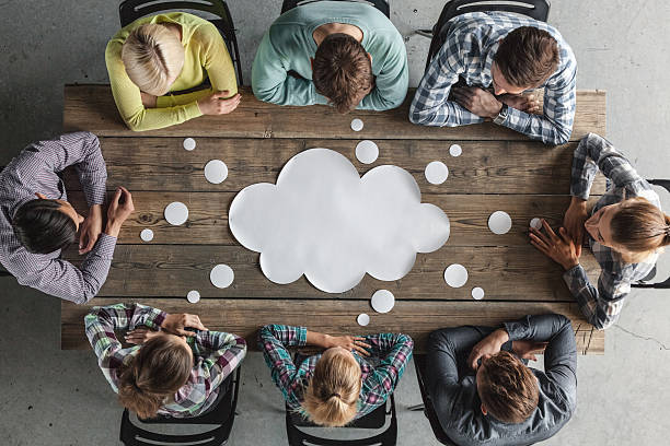 A group of eight businesspeople brainstorming around a table