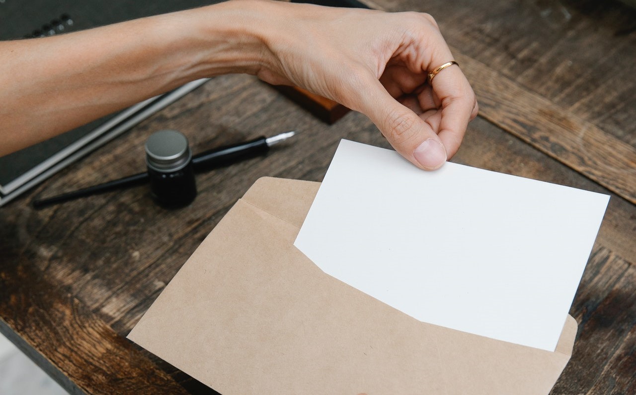 Woman retrieving letter from envelope