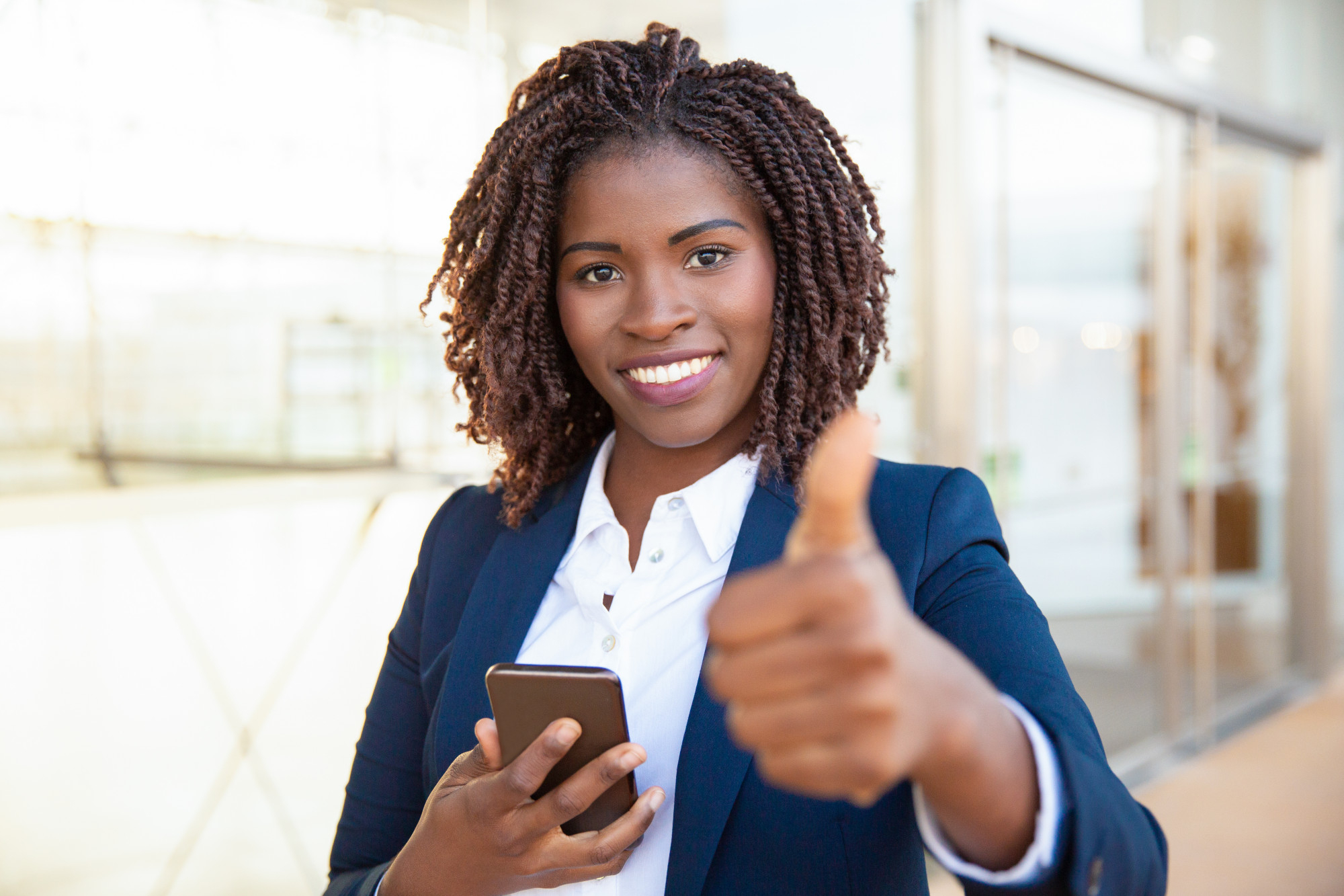 Woman with Cellphone Giving a Thumbs Up