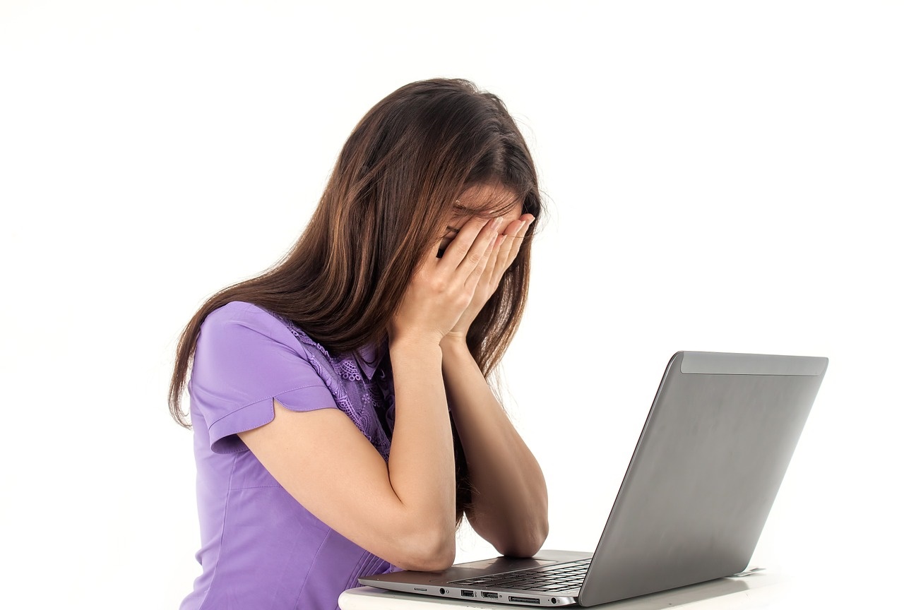 Frustrated Woman at a Computer with Head in Hands