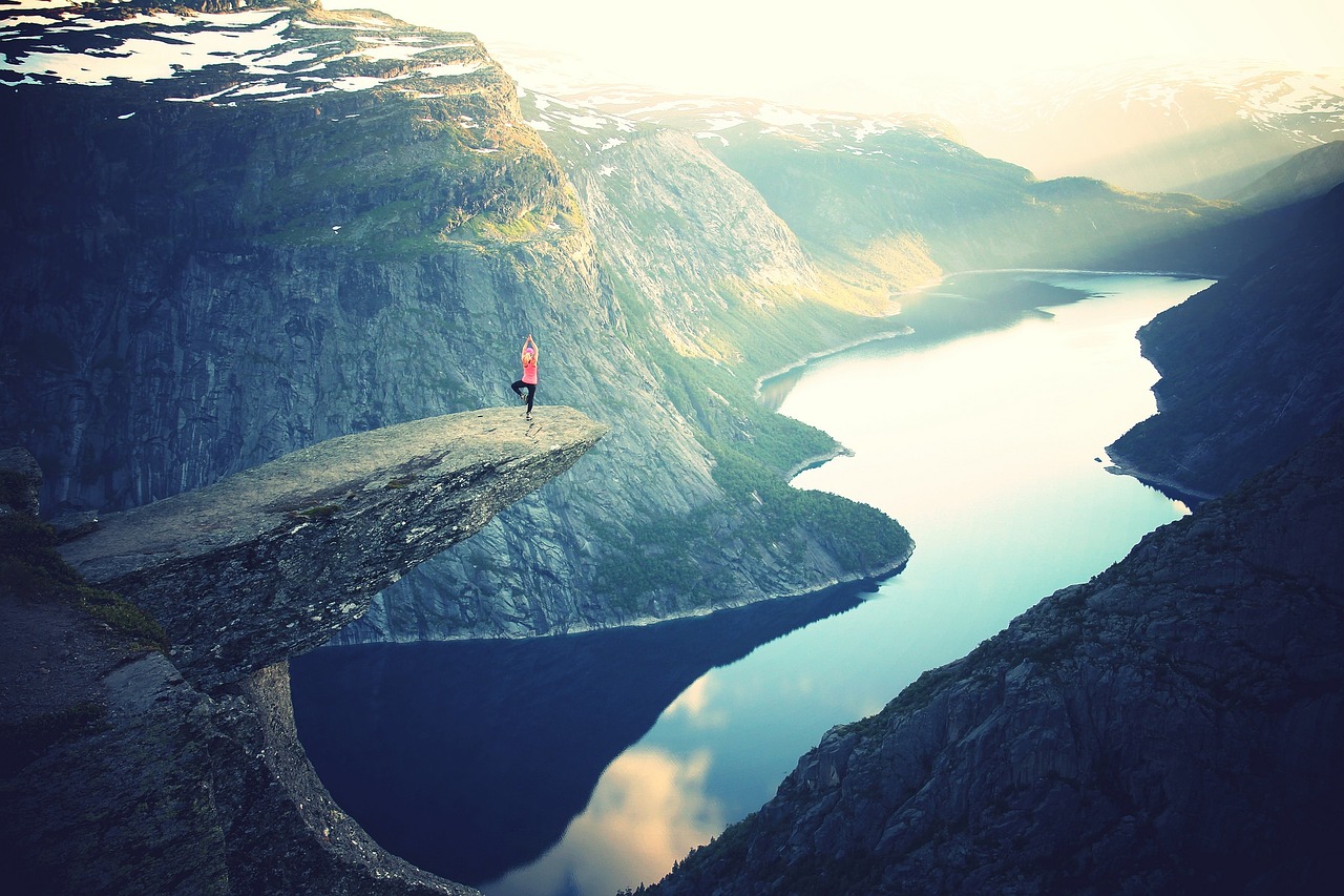 Woman Performing Yoga above a Mountain Lake